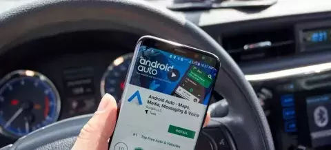 Imagen de la app Android Auto dentro de un coche frente al volante
